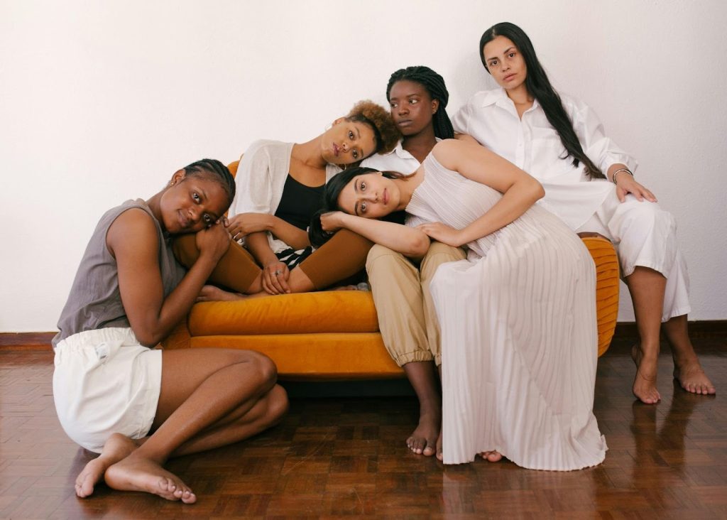 photo of women sitting together on a on sofa