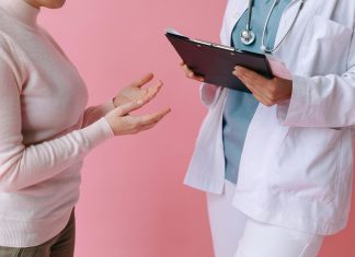 I’ve Got 99 Problems and Perimenopause is All of Them Doctor holding a clipboard talking to a woman
